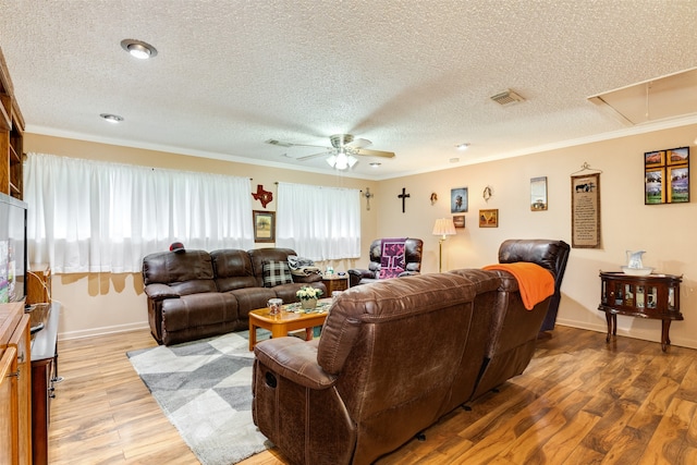 living room featuring crown molding, ceiling fan, a textured ceiling, and light wood-type flooring