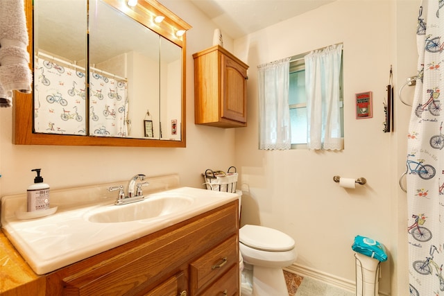 bathroom featuring vanity with extensive cabinet space and toilet