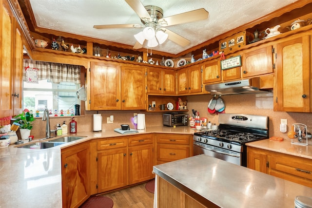 kitchen with gas stove, dark hardwood / wood-style flooring, sink, ceiling fan, and a textured ceiling