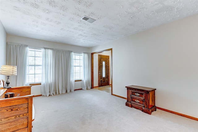 sitting room featuring light carpet and a textured ceiling