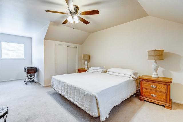 bedroom with ceiling fan, a closet, carpet, and vaulted ceiling