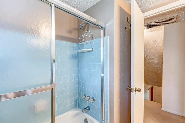 bathroom featuring a textured ceiling and tiled shower / bath combo