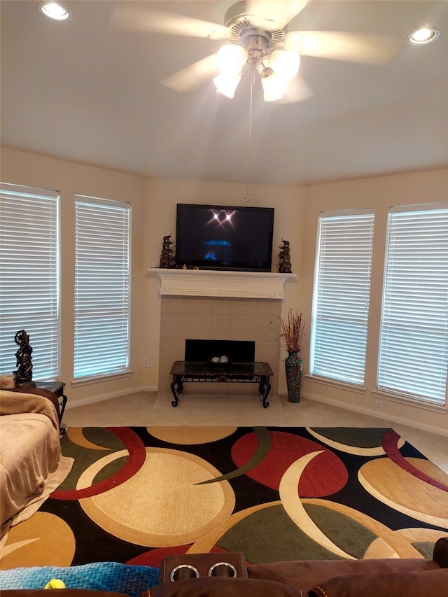 living room featuring a fireplace, a wealth of natural light, light colored carpet, and ceiling fan