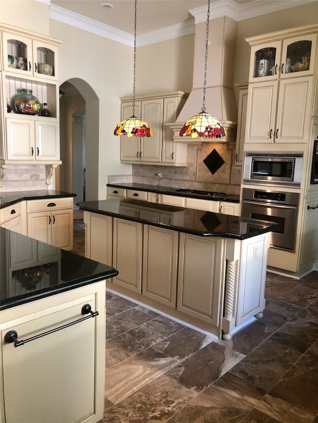 kitchen featuring appliances with stainless steel finishes, a center island, dark tile flooring, backsplash, and premium range hood