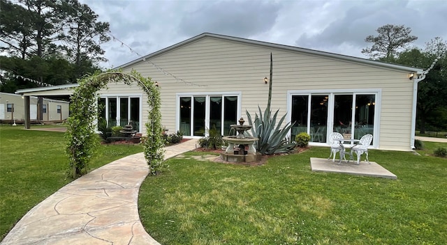 back of property with a patio area and a lawn