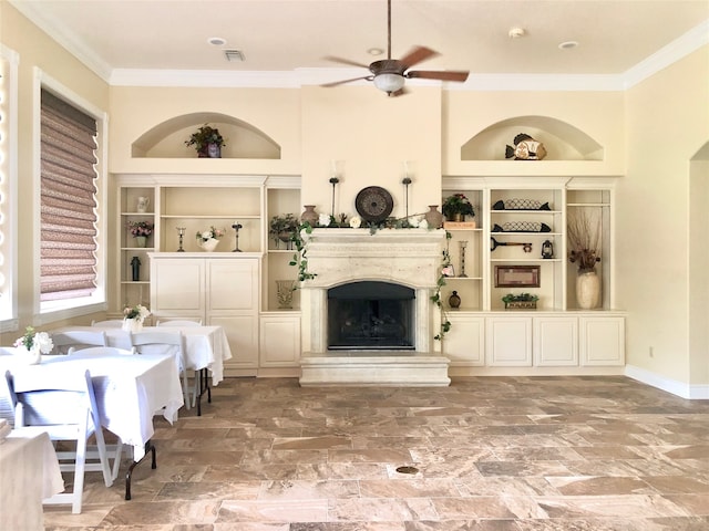 living room with ceiling fan, crown molding, and built in features