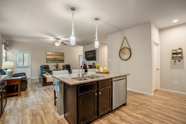 kitchen featuring stainless steel dishwasher, dark brown cabinetry, sink, light hardwood / wood-style floors, and an island with sink