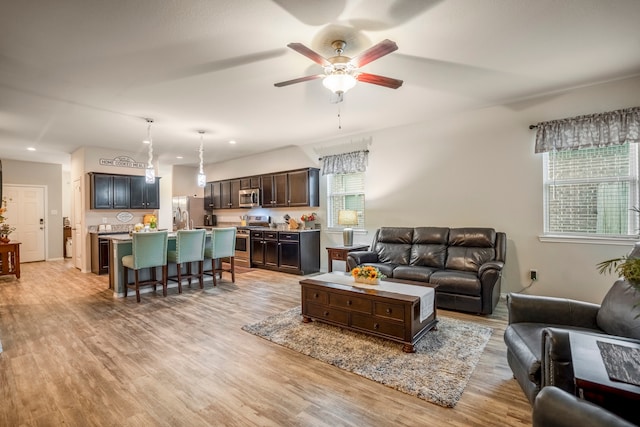 living room with ceiling fan and light wood-type flooring