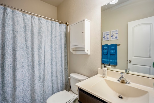 bathroom with a shower with shower curtain, vanity, and toilet