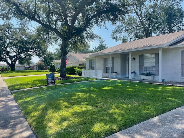 view of front of property with brick siding, a porch, a front lawn, and fence