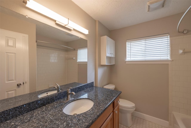 bathroom featuring vanity, baseboards, a textured ceiling, bathing tub / shower combination, and toilet