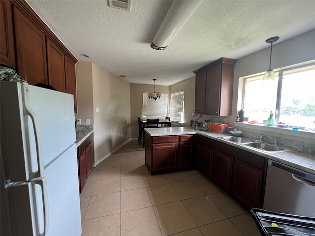 kitchen with decorative light fixtures, a notable chandelier, sink, and white fridge