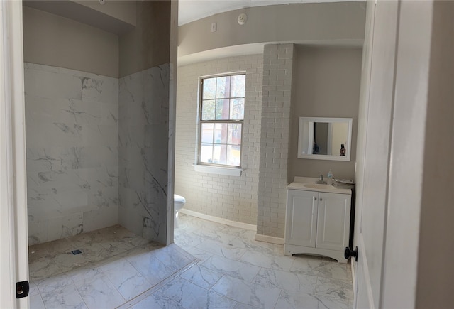 bathroom featuring toilet, vanity, tiled shower, and tile flooring