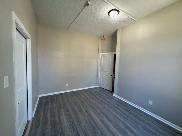 interior space featuring a textured ceiling and dark wood-type flooring