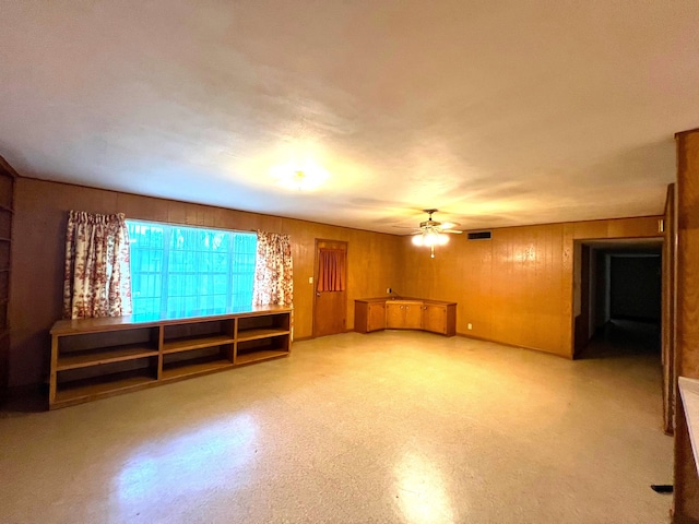 empty room with wooden walls and ceiling fan