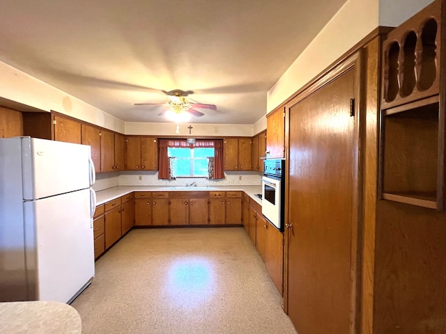 kitchen featuring white fridge, ceiling fan, and sink