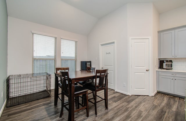 dining room featuring lofted ceiling and dark hardwood / wood-style floors