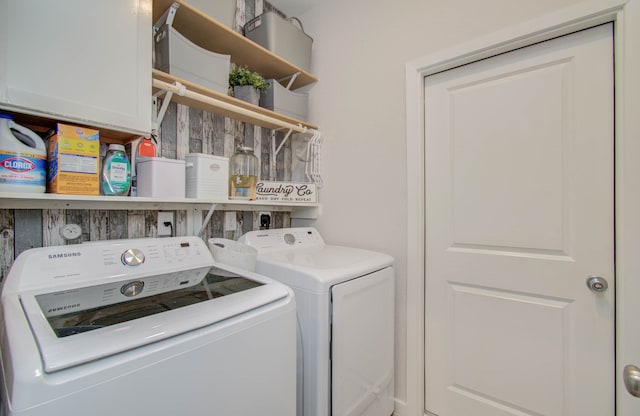 clothes washing area featuring hookup for an electric dryer, independent washer and dryer, and cabinets