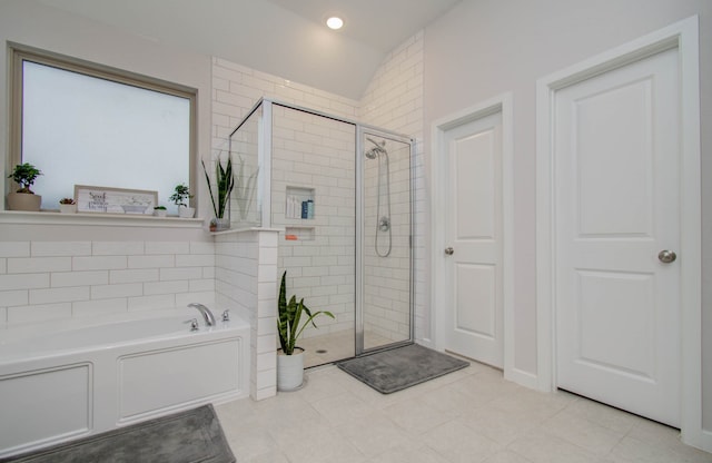 bathroom featuring shower with separate bathtub and tile floors