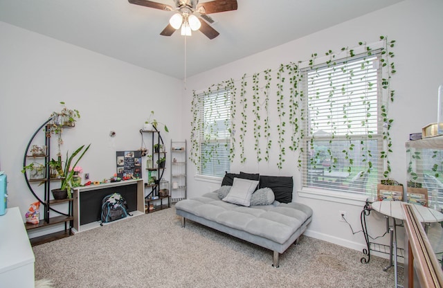 living area with light carpet and ceiling fan