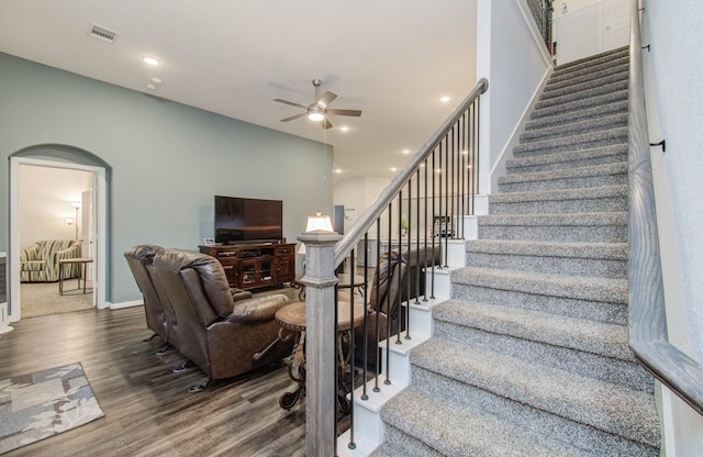 stairway with dark hardwood / wood-style floors and ceiling fan