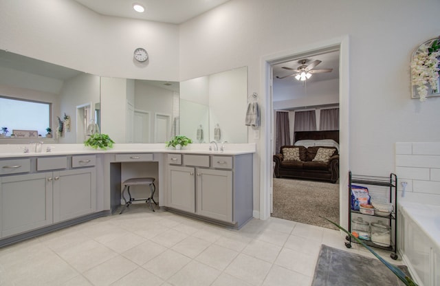 bathroom with a bathing tub, ceiling fan, double sink vanity, and tile flooring