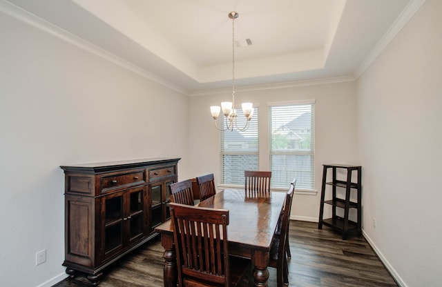 dining area with crown molding, an inviting chandelier, dark hardwood / wood-style flooring, and a tray ceiling