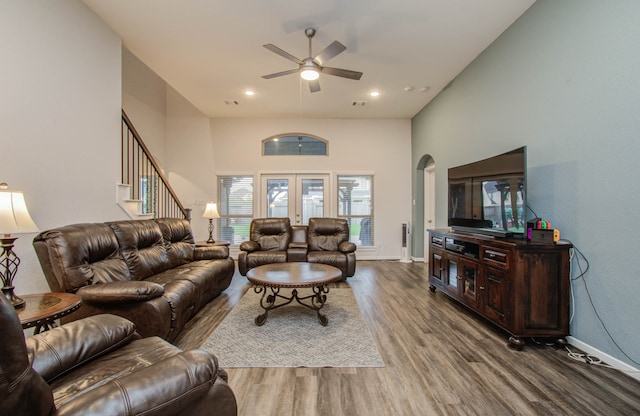 living room featuring french doors, hardwood / wood-style floors, ceiling fan, and a towering ceiling