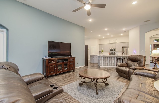 living room with ceiling fan and light wood-type flooring