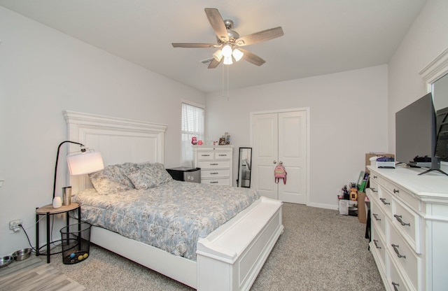 bedroom featuring light carpet, a closet, and ceiling fan