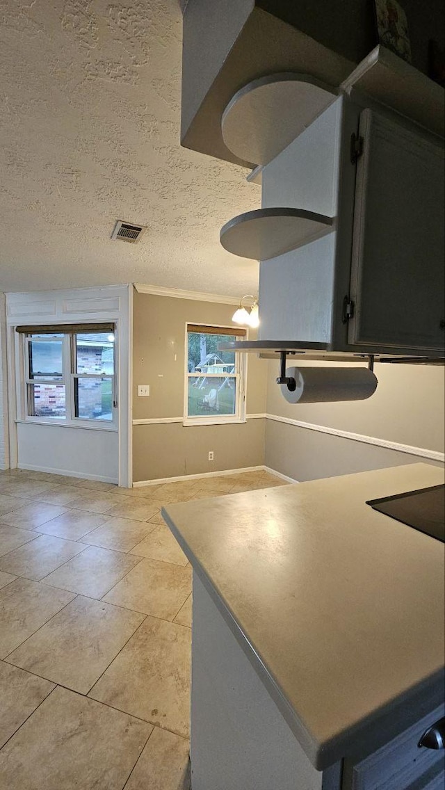 kitchen with light tile patterned flooring, an inviting chandelier, and a textured ceiling