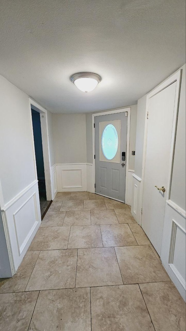 interior space featuring light tile patterned floors and a textured ceiling