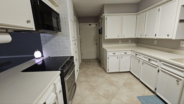 kitchen featuring white cabinets, light tile patterned floors, and stainless steel range with electric cooktop