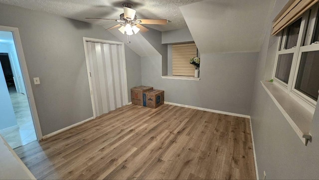 additional living space with wood-type flooring, ceiling fan, and a textured ceiling