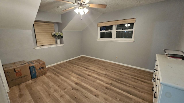 bonus room featuring hardwood / wood-style flooring, ceiling fan, lofted ceiling, and a textured ceiling