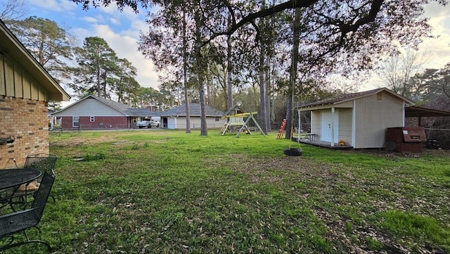 view of yard with a storage shed and a playground