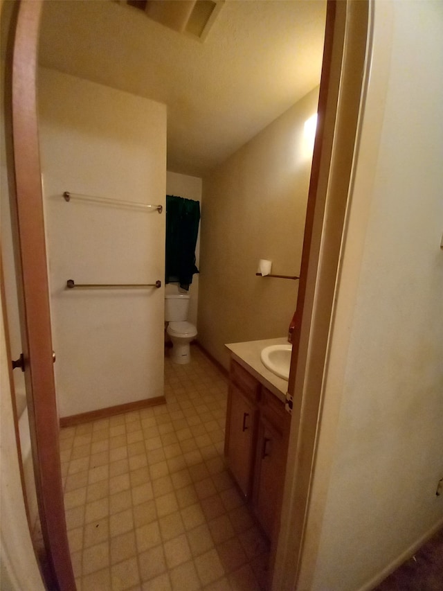 bathroom featuring vanity, tile flooring, and toilet