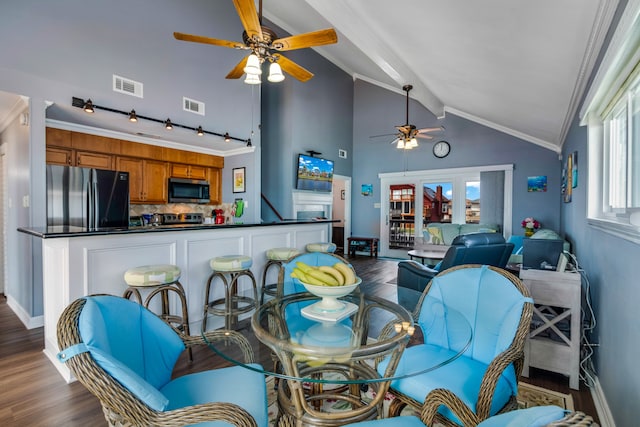 interior space featuring ceiling fan, crown molding, dark hardwood / wood-style flooring, lofted ceiling with beams, and track lighting