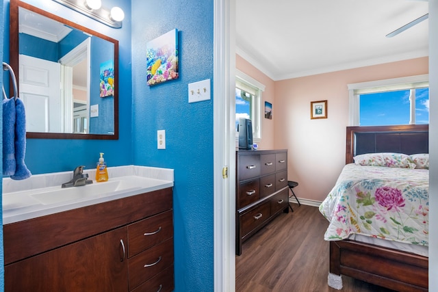 bedroom featuring crown molding, ceiling fan, dark wood-type flooring, and sink