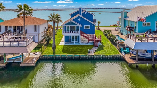 exterior space featuring a lawn, a deck with water view, and a patio