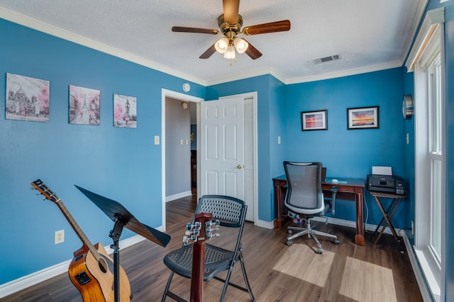 home office with crown molding, ceiling fan, and dark wood-type flooring