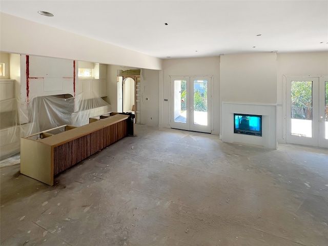 unfurnished living room with plenty of natural light and french doors