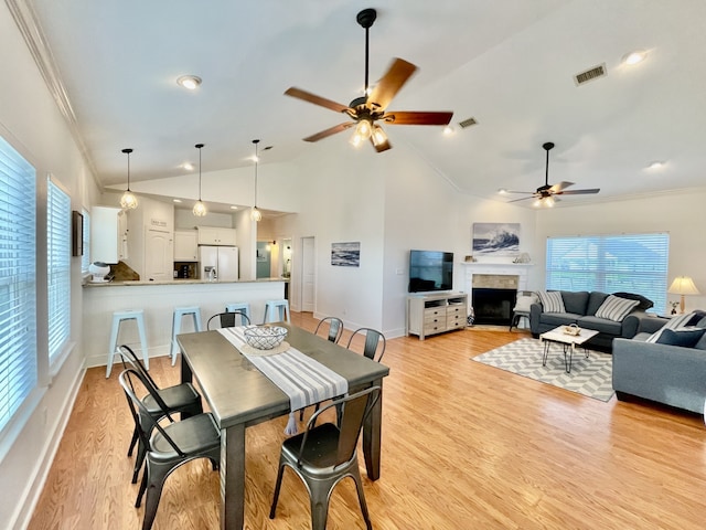 dining space with ornamental molding, ceiling fan, light wood-type flooring, and a wealth of natural light