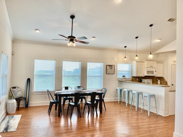 dining room with light hardwood / wood-style flooring, ornamental molding, ceiling fan, and sink