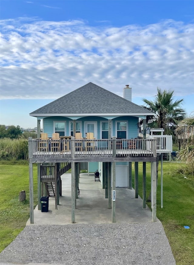 rear view of property with a wooden deck and a lawn