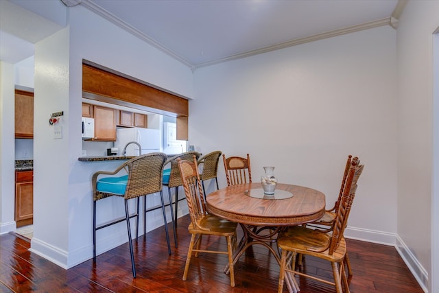 dining room with crown molding and dark hardwood / wood-style flooring