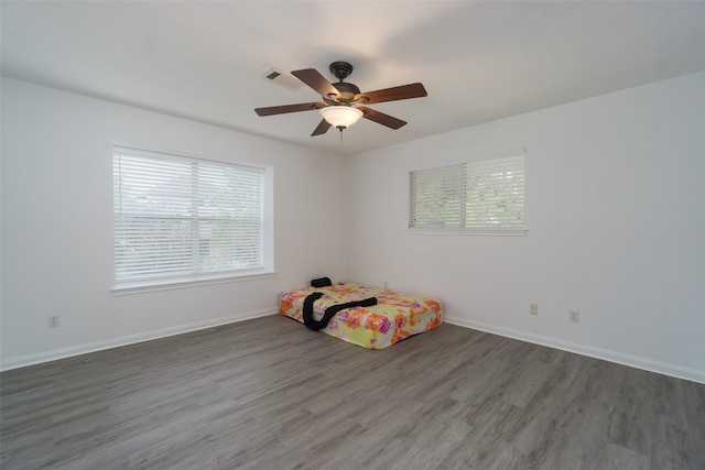 unfurnished bedroom with dark hardwood / wood-style flooring and ceiling fan