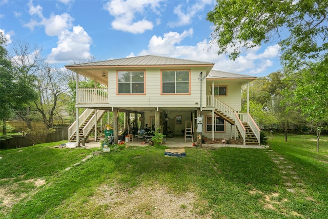 back of house featuring a lawn and a patio area