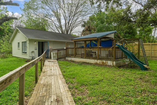 rear view of house featuring a playground and a yard