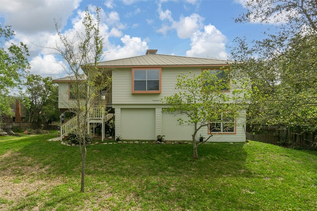 rear view of property featuring a lawn